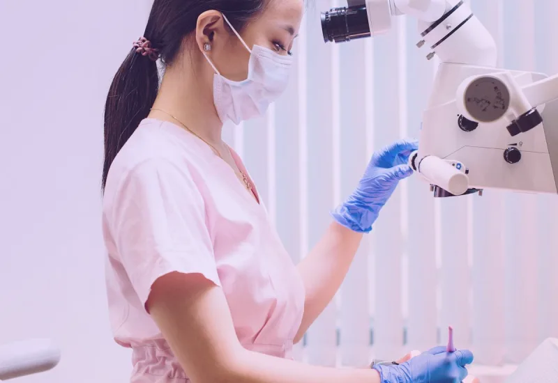 Endodoncista realizando un tratamiento de conductos con microscopio operatorio