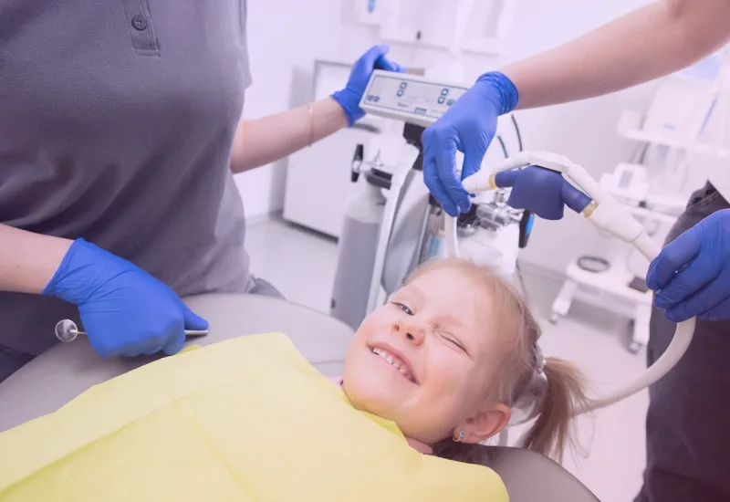 Niña sonriente en la consulta del dentista durante una revisión infantil